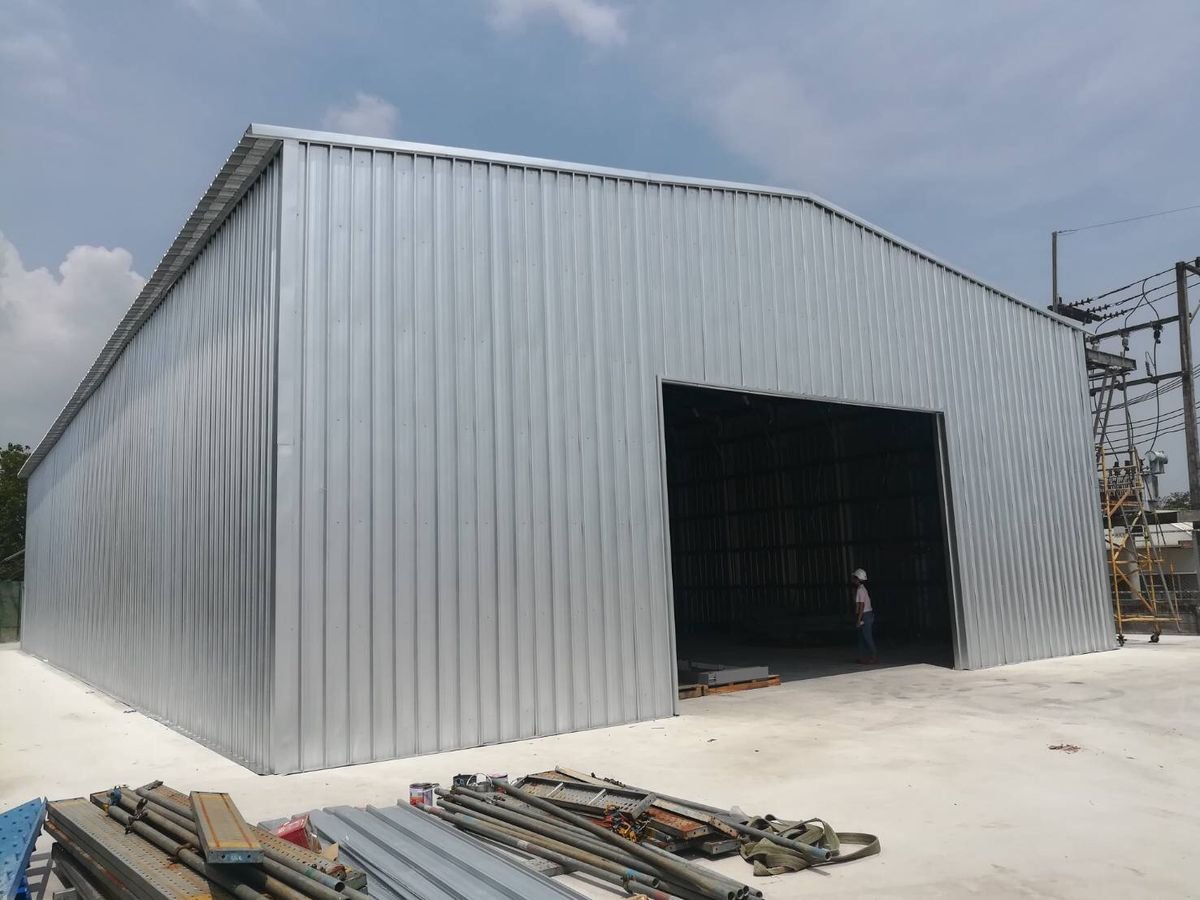 عمال يقومون بتركيب هيكل هنجر معدني في موقع المشروع